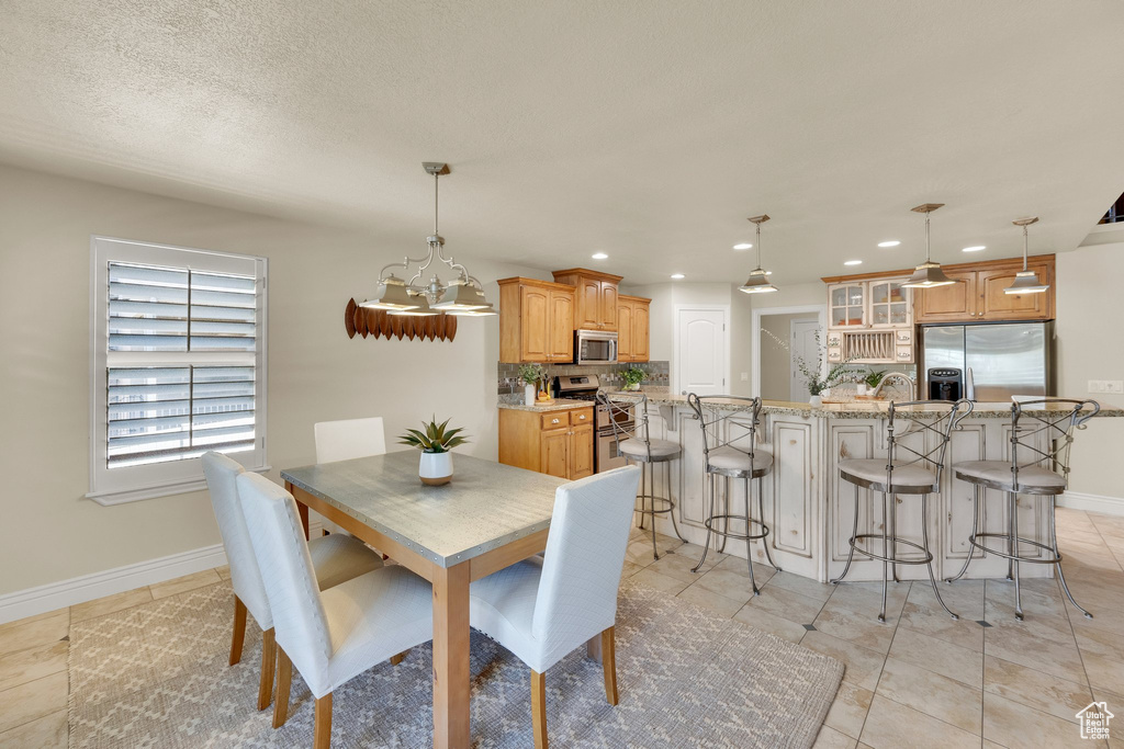 Dining room featuring baseboards, recessed lighting, a chandelier, and light tile patterned floors