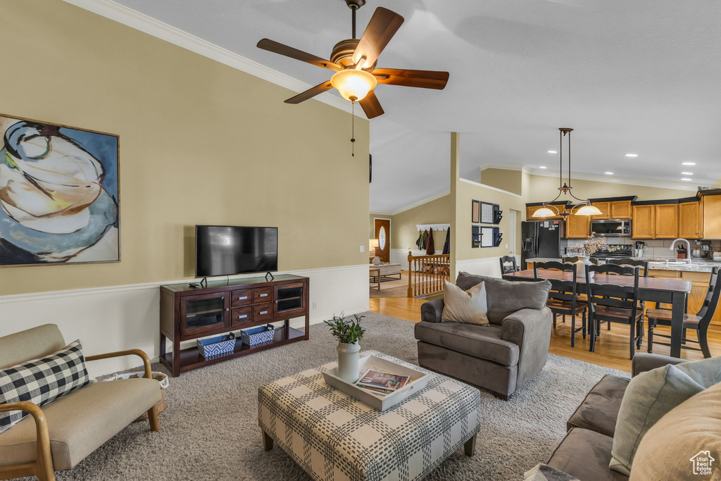 Living area featuring lofted ceiling, crown molding, ceiling fan, recessed lighting, and baseboards