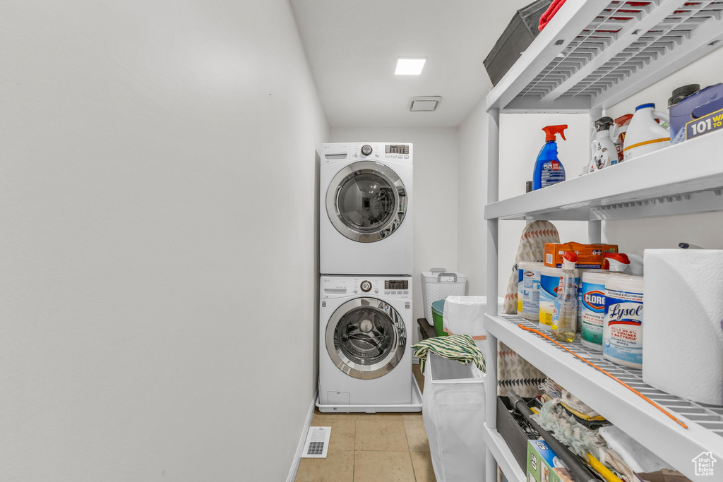 Washroom with estacked washer and dryer and baseboards