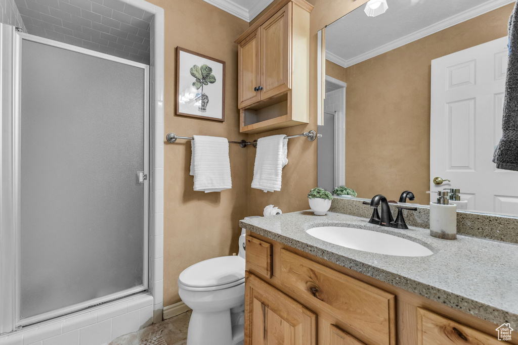 Full bath with a shower stall, vanity, crown molding, and toilet