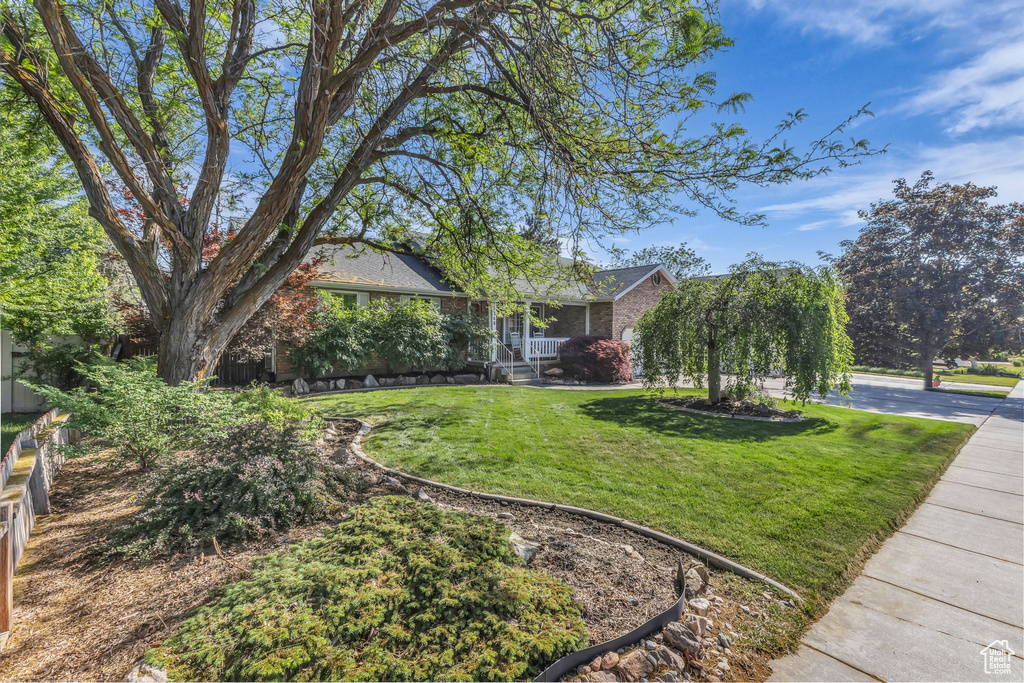 View of front facade featuring a front yard and brick siding