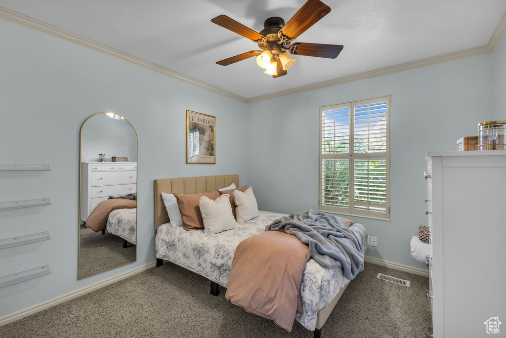 Carpeted bedroom with crown molding, baseboards, and a ceiling fan