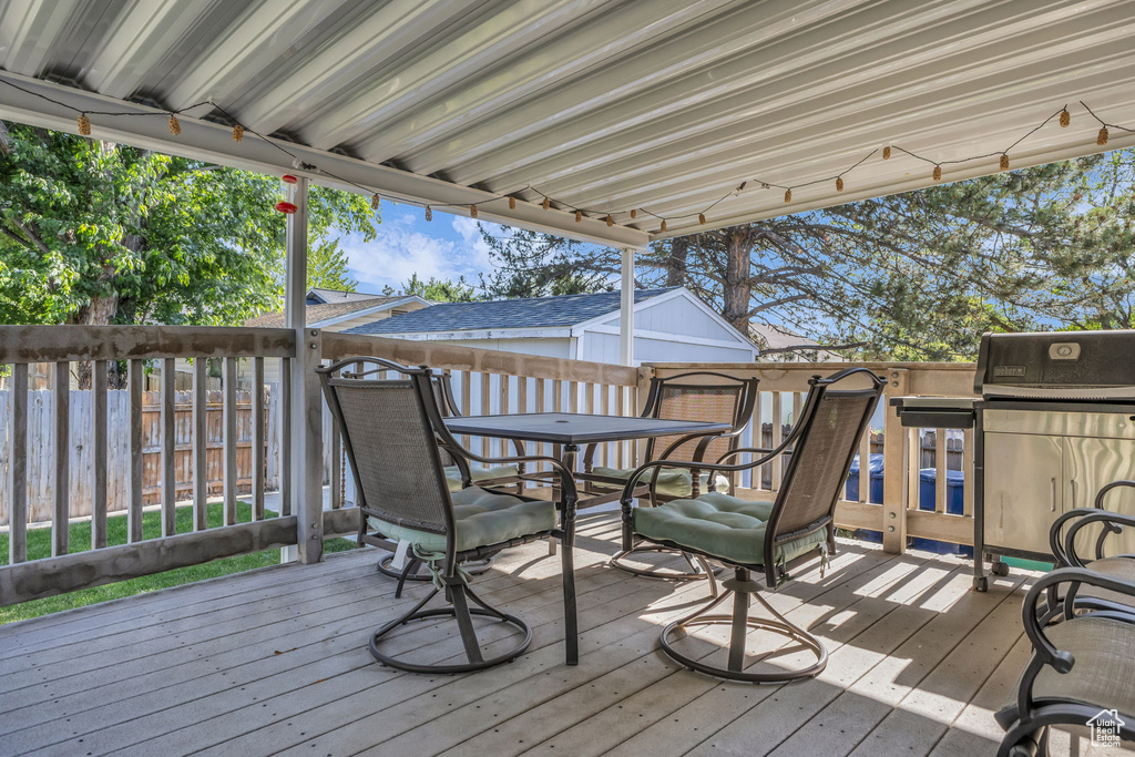Wooden terrace featuring outdoor dining area and area for grilling