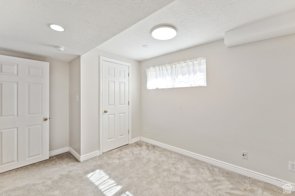 Basement with carpet and a textured ceiling