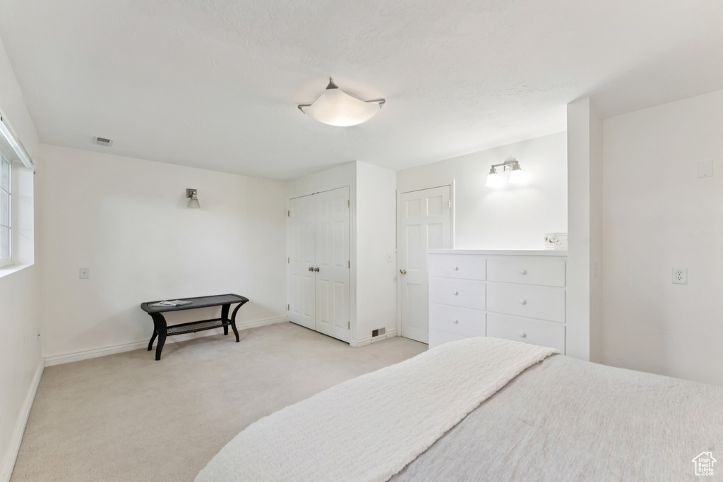 Bedroom featuring light carpet and baseboards