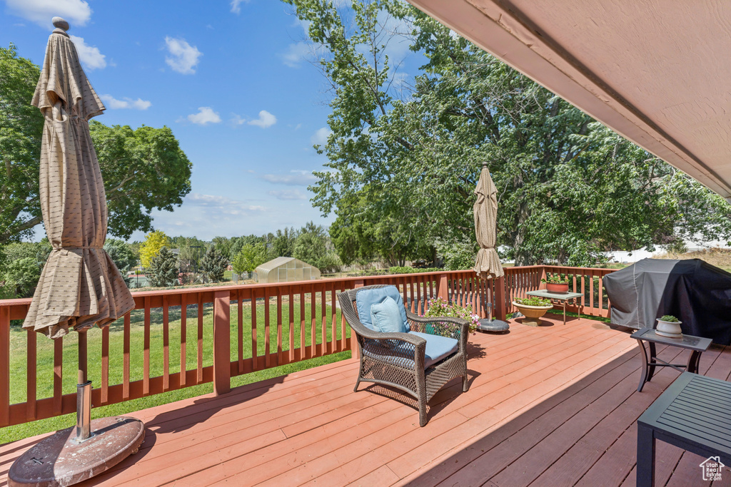 Wooden terrace featuring area for grilling and a yard