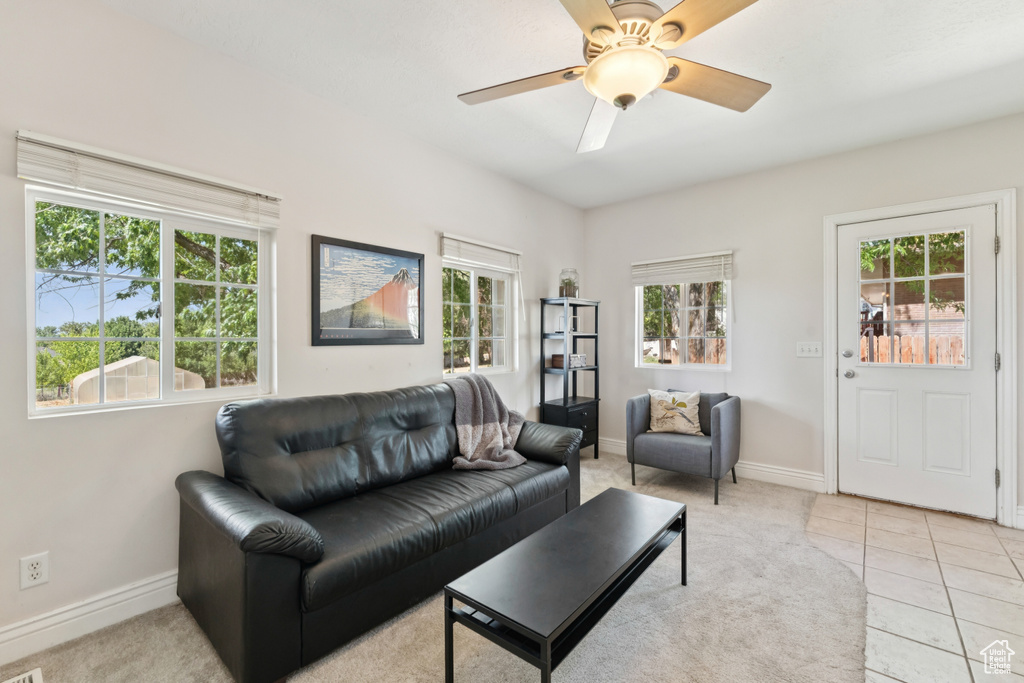 Living room featuring plenty of natural light, ceiling fan, light tile patterned floors, and light colored carpet
