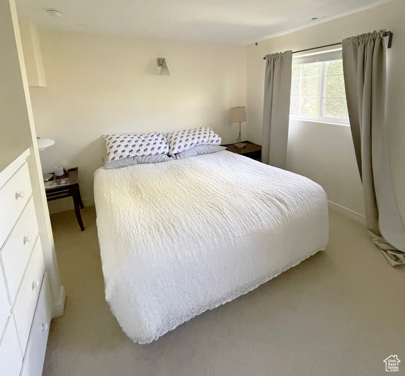Bedroom with light carpet and baseboards