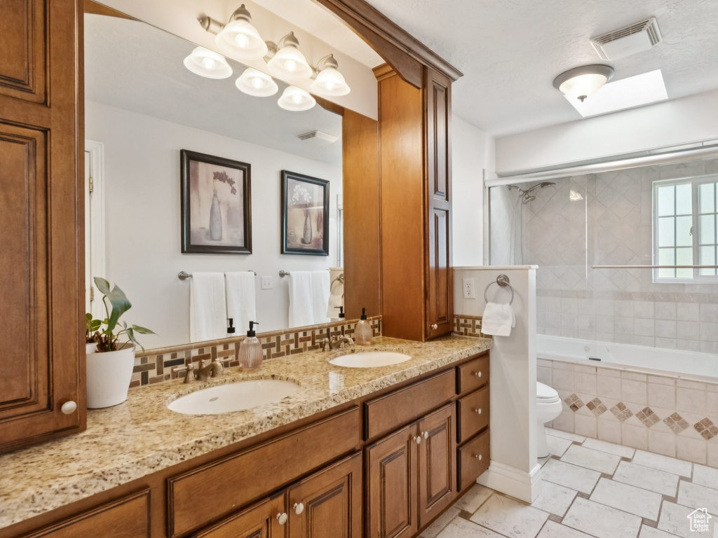 Bathroom with double vanity, tiled shower / bath, and tile patterned floors