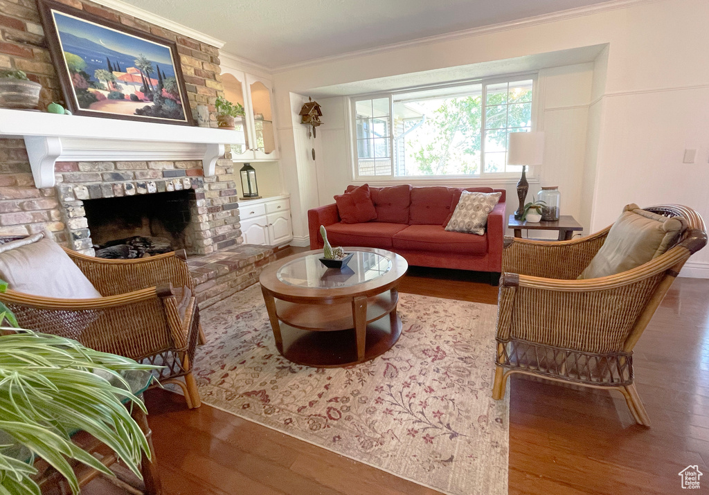 Living area featuring crown molding, wood finished floors, and a fireplace