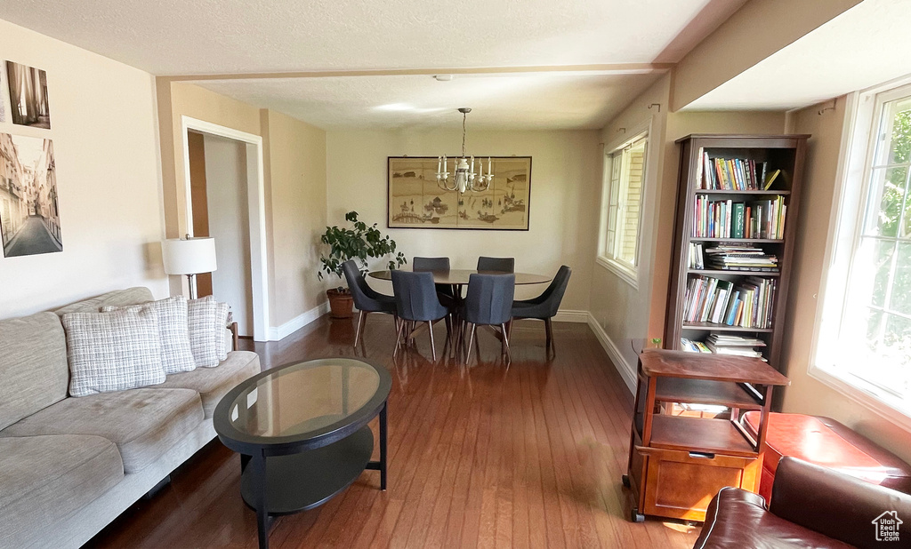 Living area with wood-type flooring, a chandelier, and baseboards