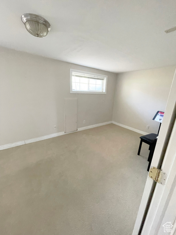 Basement with light carpet and baseboards