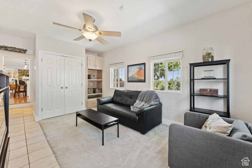 Living area with a ceiling fan and light tile patterned floors