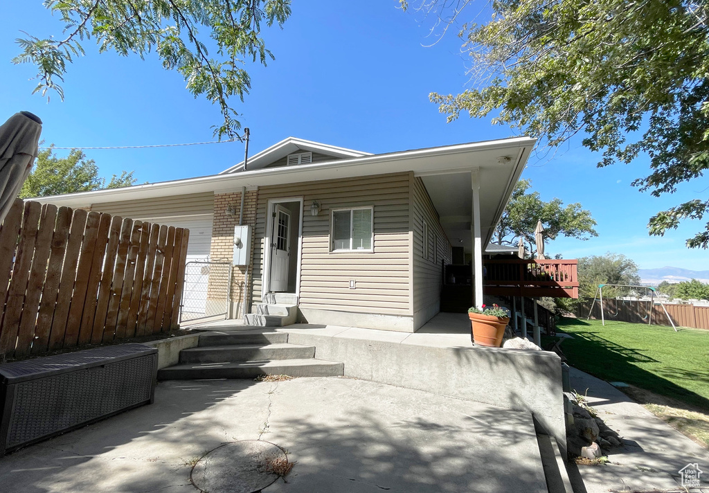 View of front of property featuring a patio, a deck, and brick siding