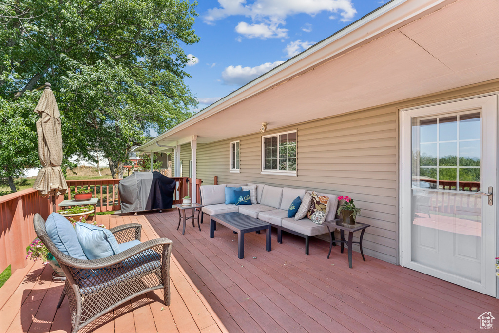 Wooden terrace featuring an outdoor hangout area and grilling area