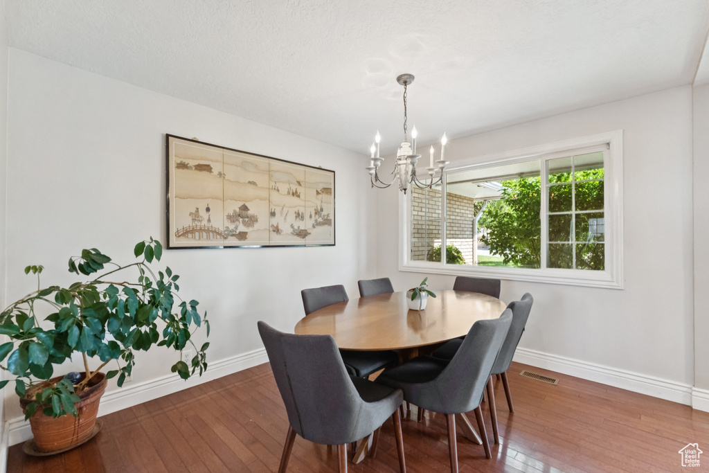 Dining area with a chandelier and wood-type flooring