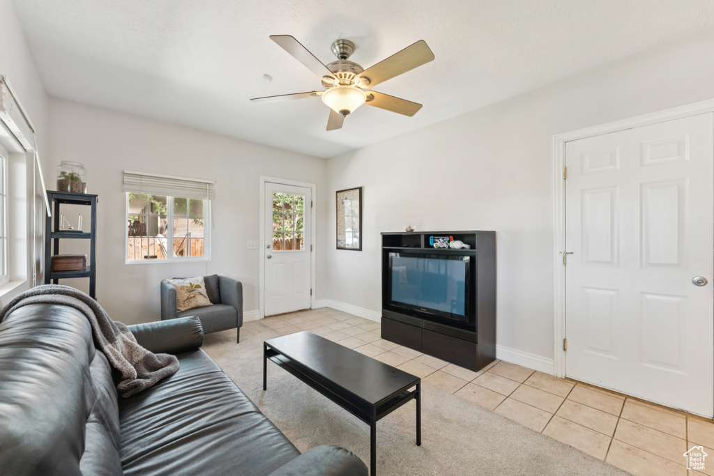 Living area with a ceiling fan and light tile patterned floors