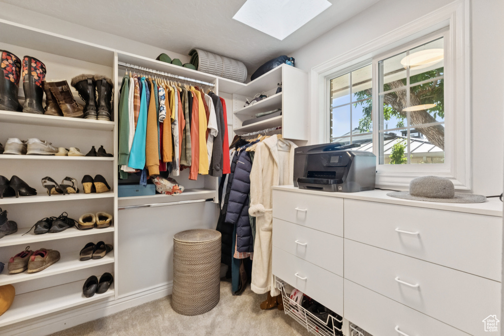 Walk in closet featuring a skylight and carpet