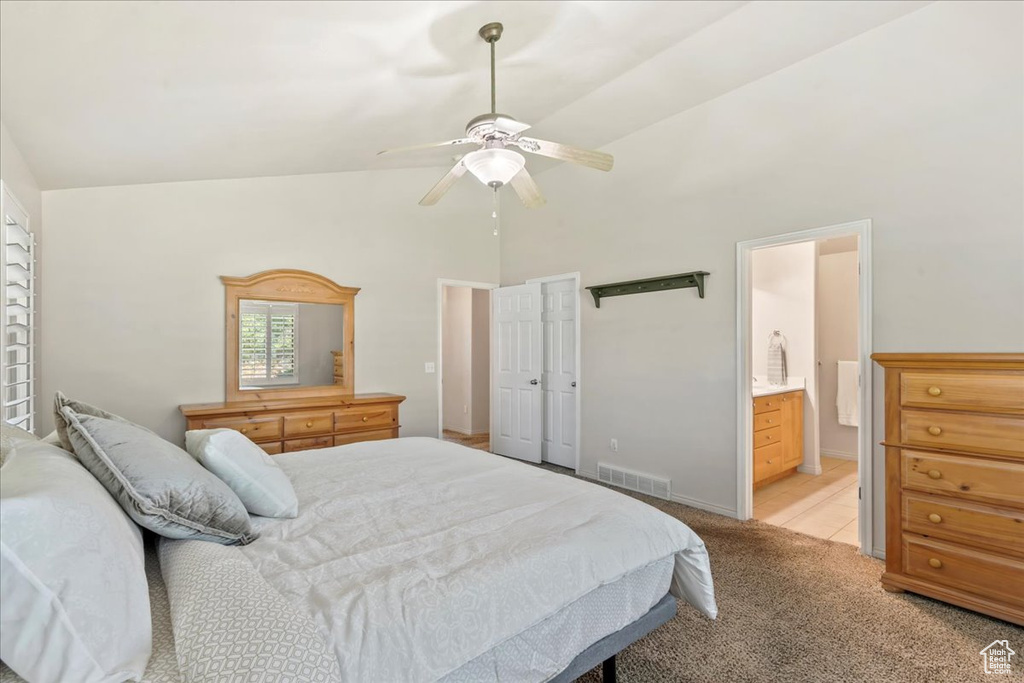 Bedroom featuring high vaulted ceiling, light carpet, connected bathroom, a ceiling fan, and baseboards