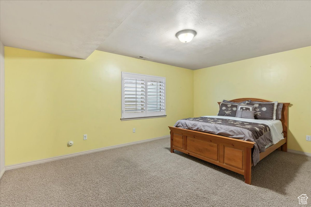 Carpeted bedroom with baseboards and a textured ceiling