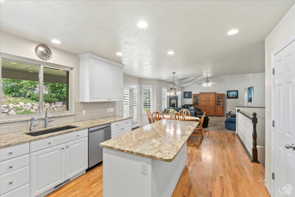 Kitchen featuring a sink, stainless steel dishwasher, a kitchen island, light wood-style floors, and ceiling fan