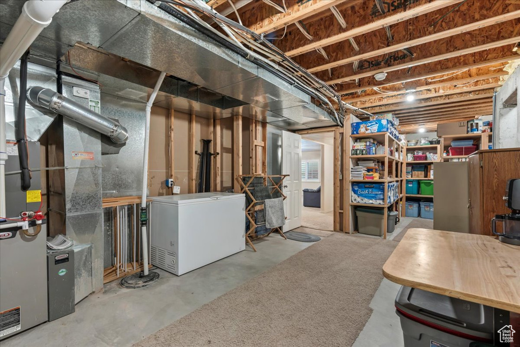Unfinished basement featuring fridge