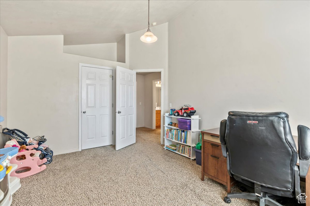 Home office featuring light colored carpet, high vaulted ceiling, and baseboards