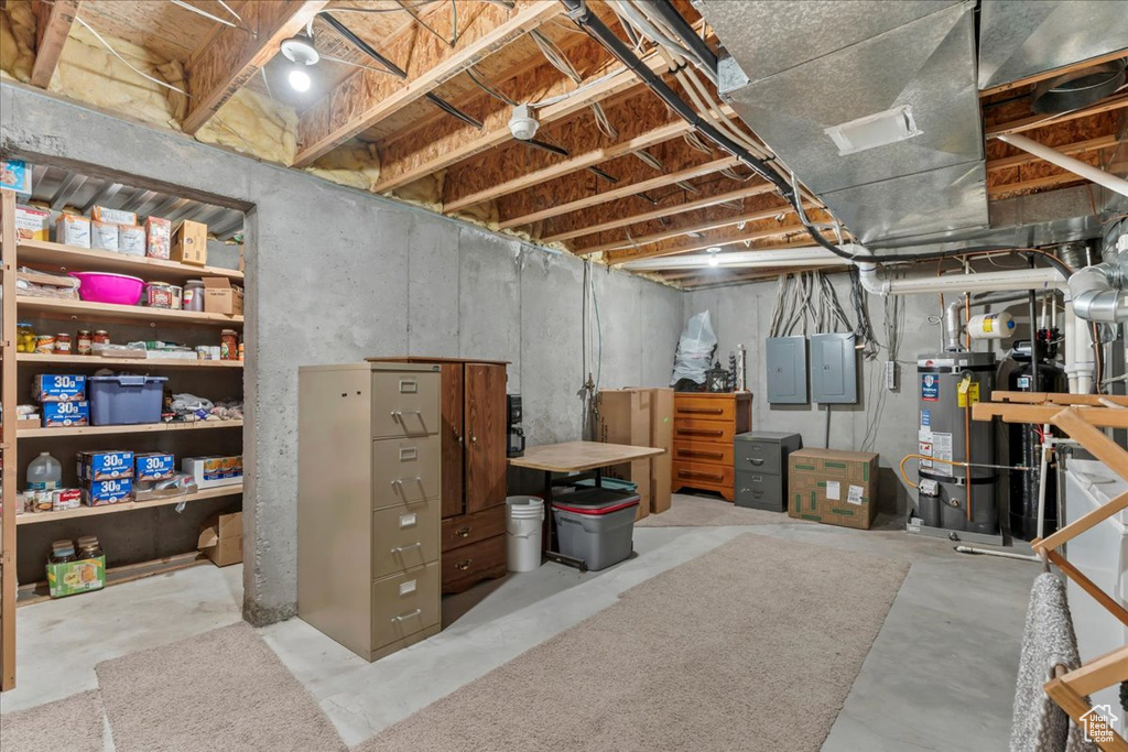 Unfinished below grade area featuring strapped water heater and electric panel