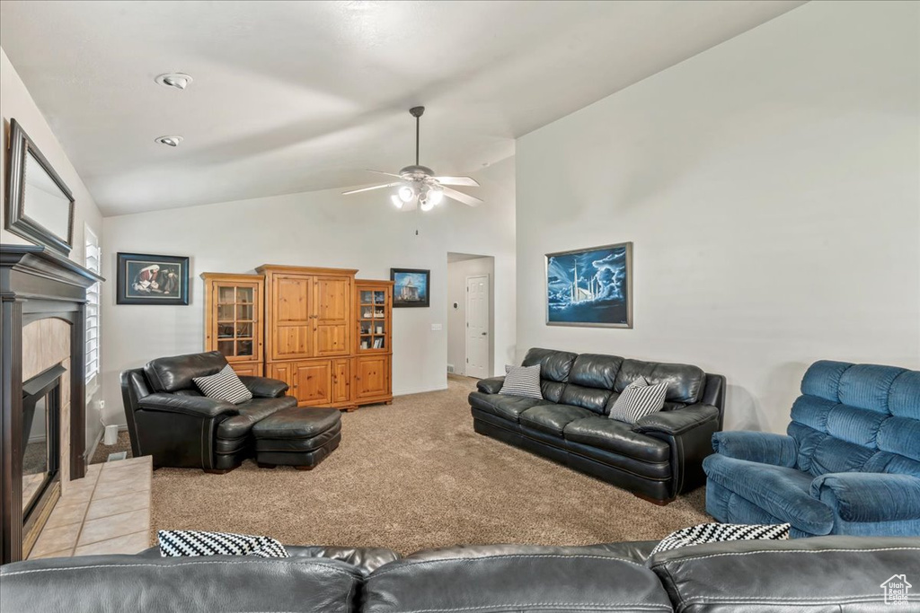 Living area with light carpet, lofted ceiling, ceiling fan, and a glass covered fireplace