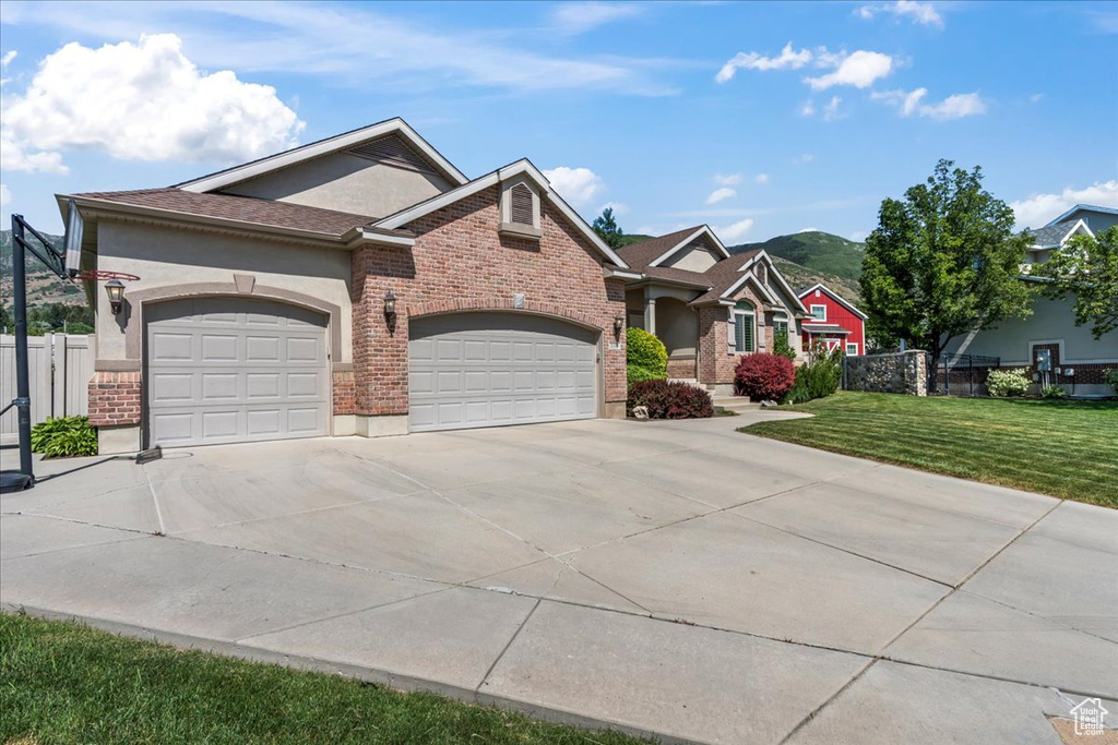 View of front of home featuring concrete driveway, an attached garage, stucco siding, and brick siding