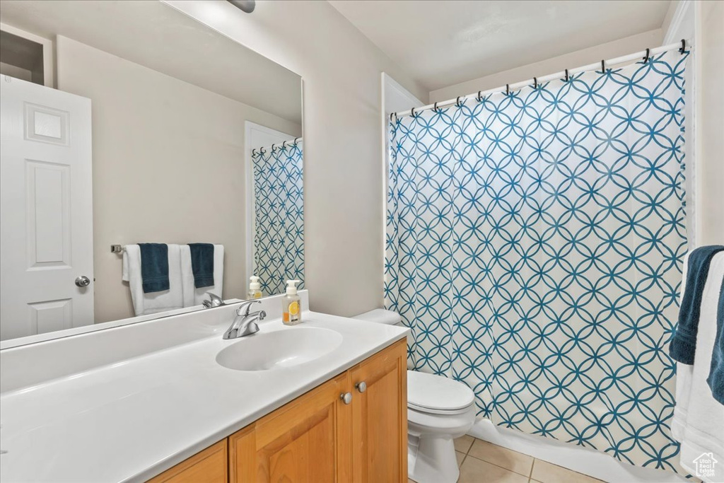 Full bathroom with toilet, vanity, tile patterned flooring, and a shower with curtain