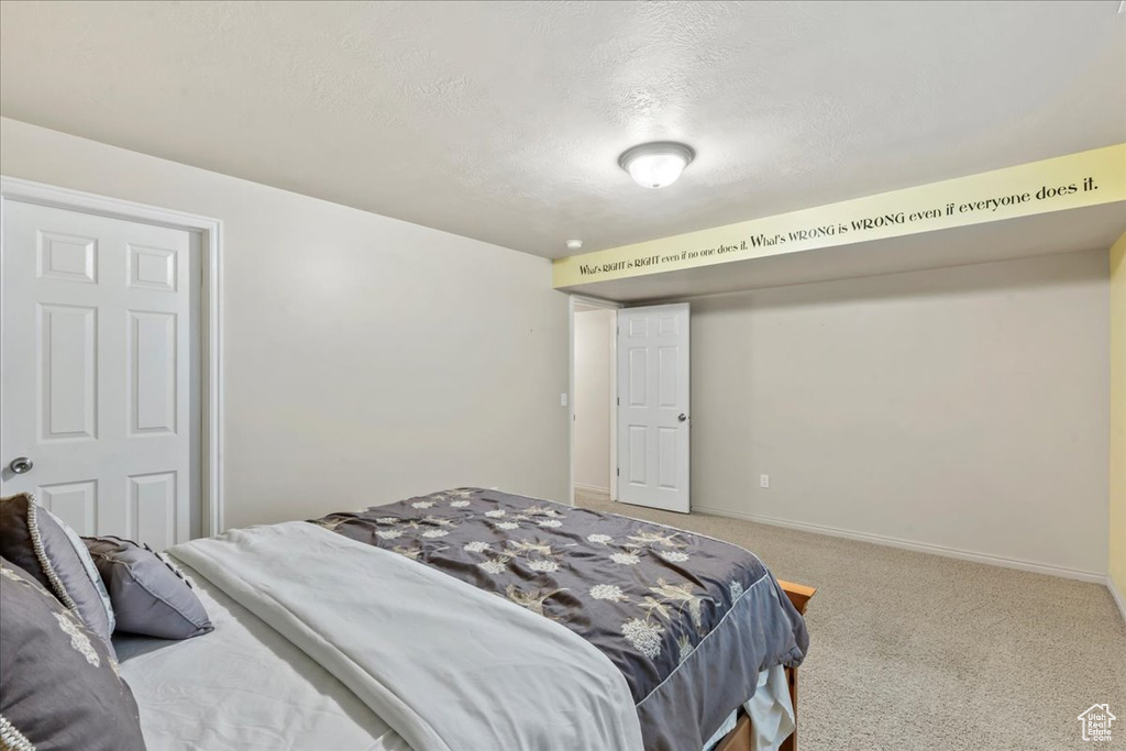 Carpeted bedroom with a textured ceiling and baseboards