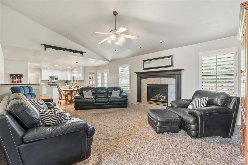 Living area with a ceiling fan, carpet flooring, a tile fireplace, a chandelier, and recessed lighting