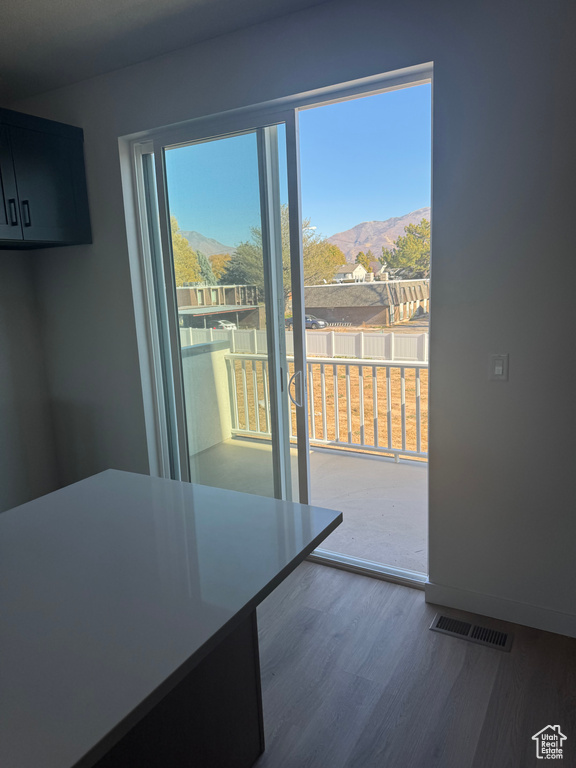 Unfurnished dining area with a mountain view, dark wood-style flooring, and baseboards