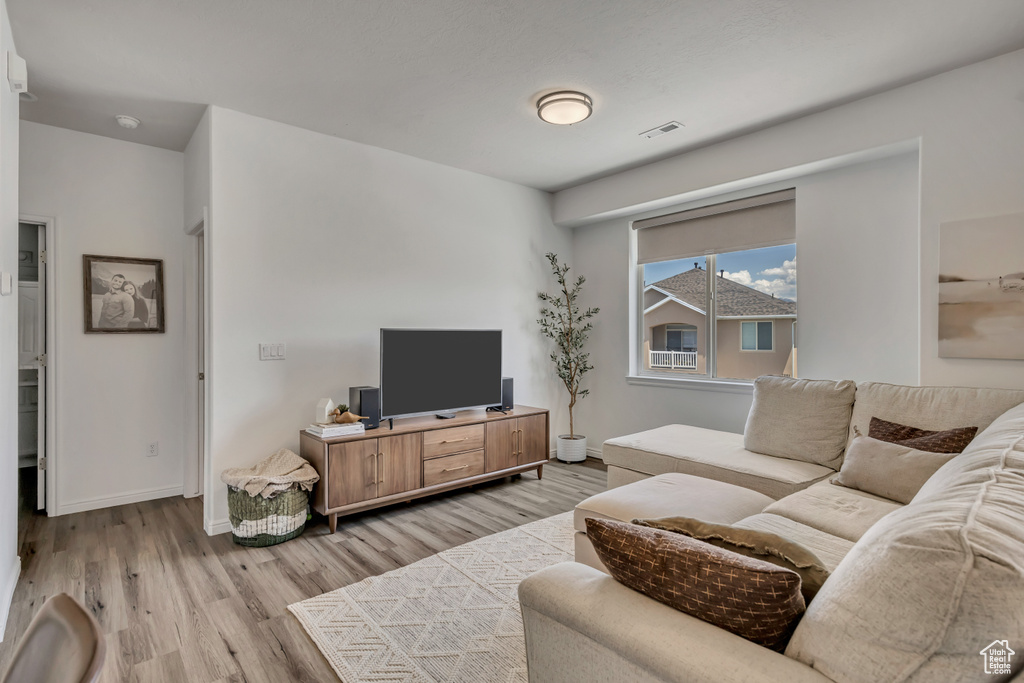 Living room featuring light wood-type flooring and baseboards