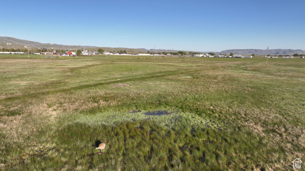 View of green lawn with a view of rural / pastoral area and a mountain view