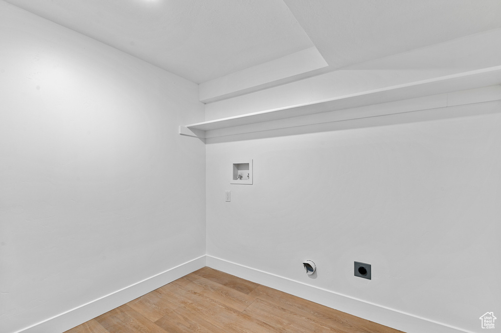 Laundry area featuring washer hookup, hookup for an electric dryer, light wood finished floors, and baseboards