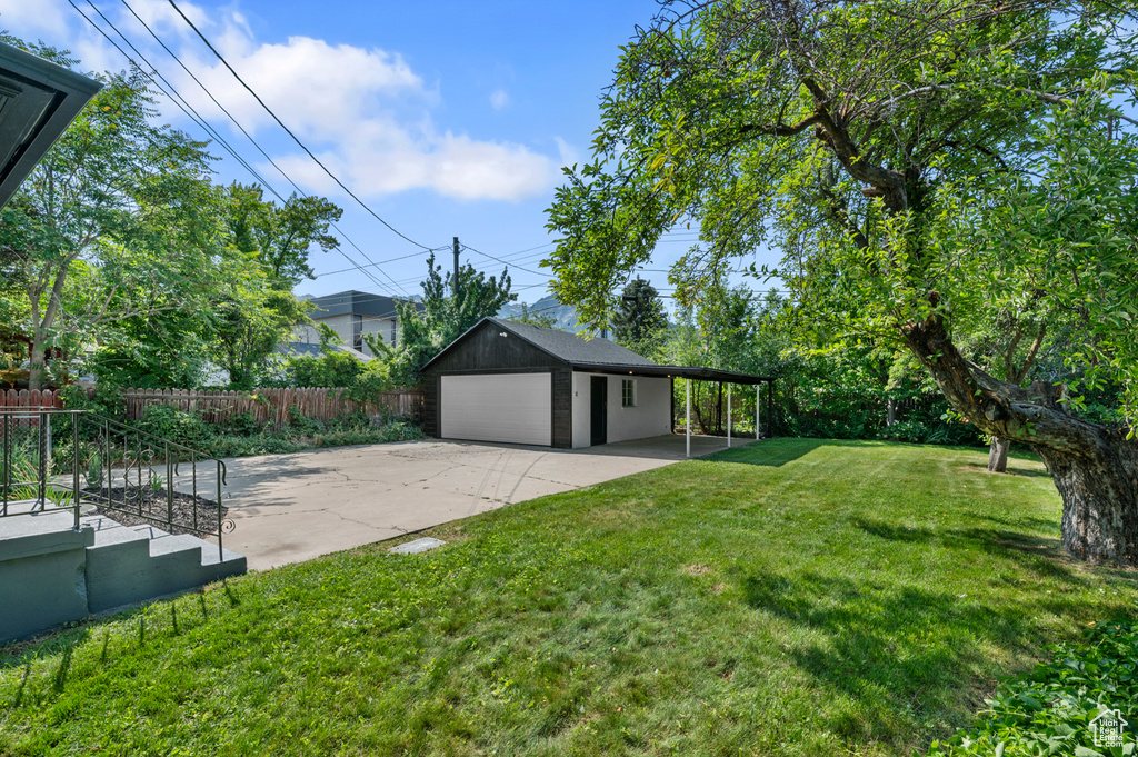 View of yard featuring a garage and an outbuilding