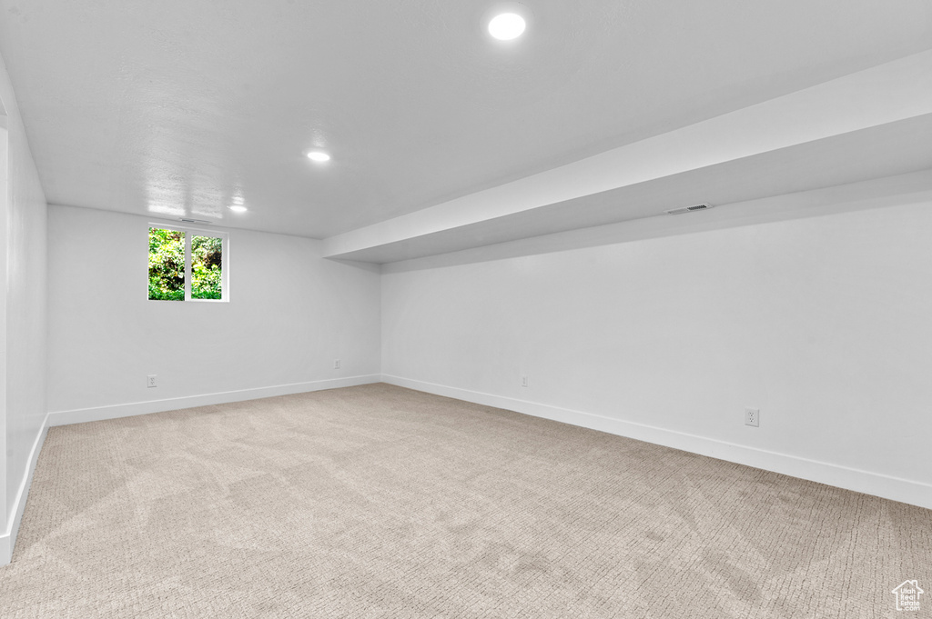 Below grade area featuring baseboards, light carpet, and recessed lighting