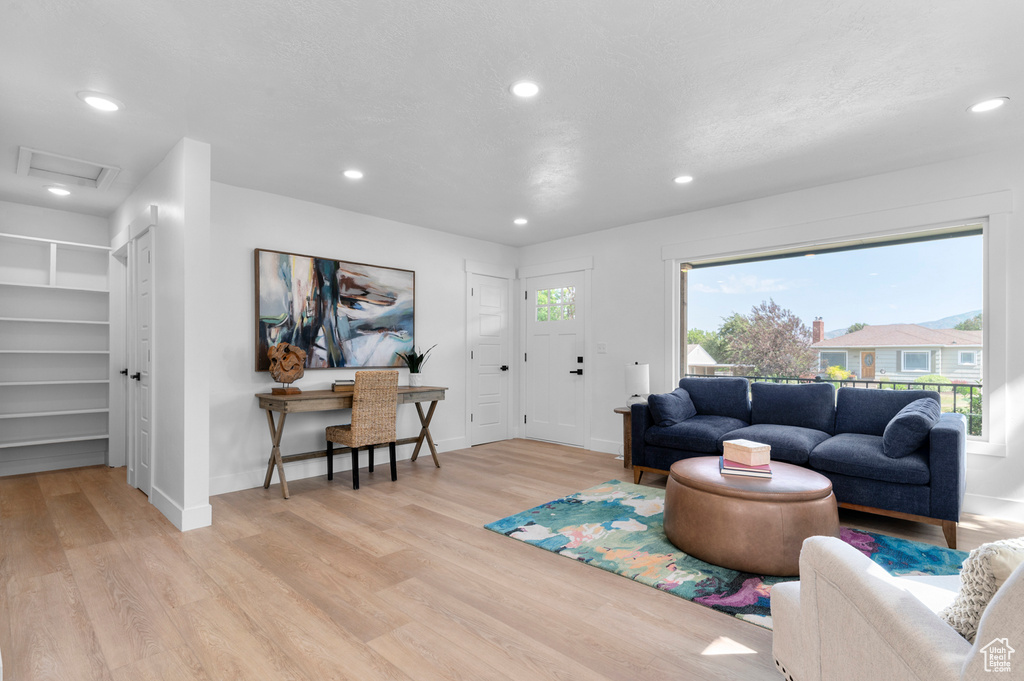 Living room featuring light wood-style floors, recessed lighting, baseboards, and attic access