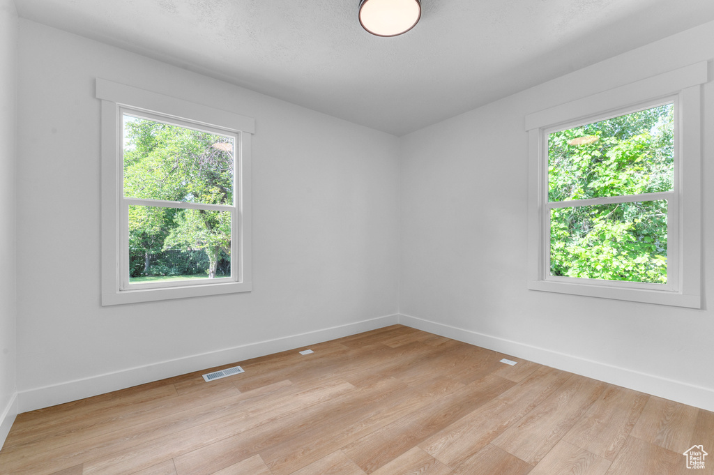Empty room with light wood-style flooring and baseboards