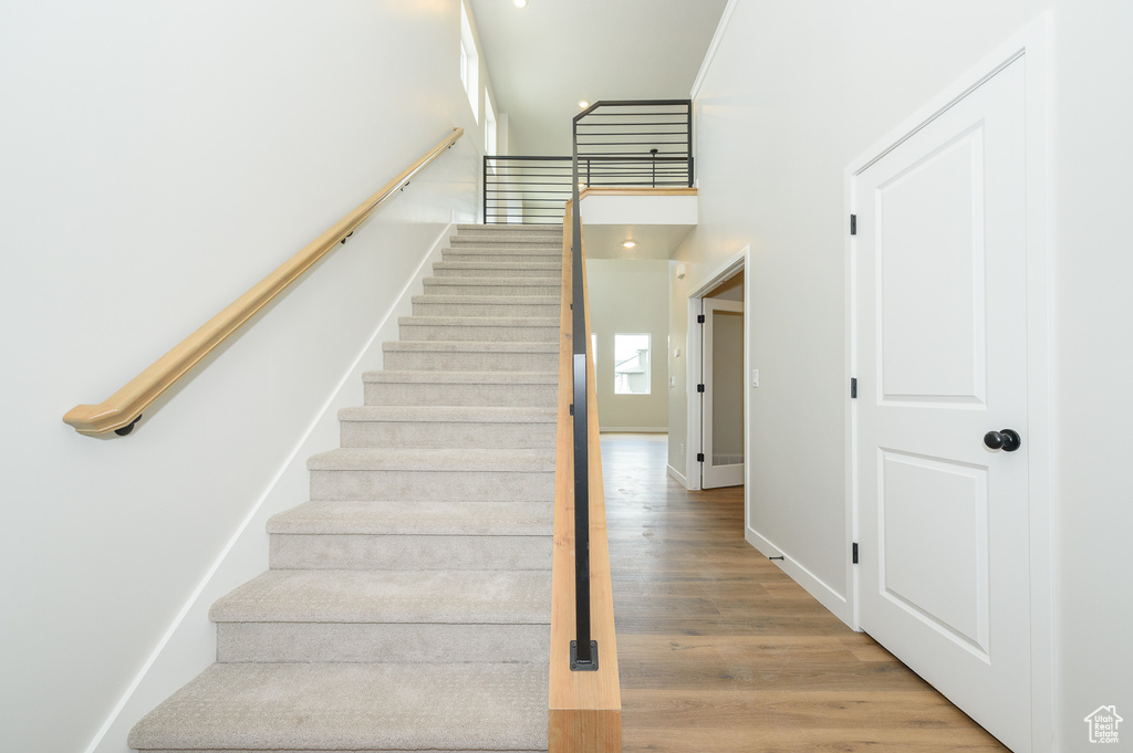 Stairway featuring wood finished floors