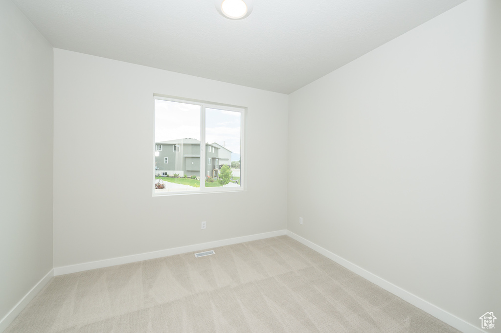 Unfurnished room with light carpet and baseboards