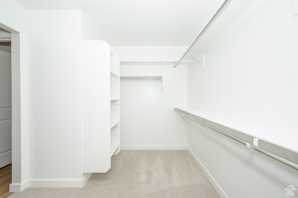 Walk in closet with light carpet
