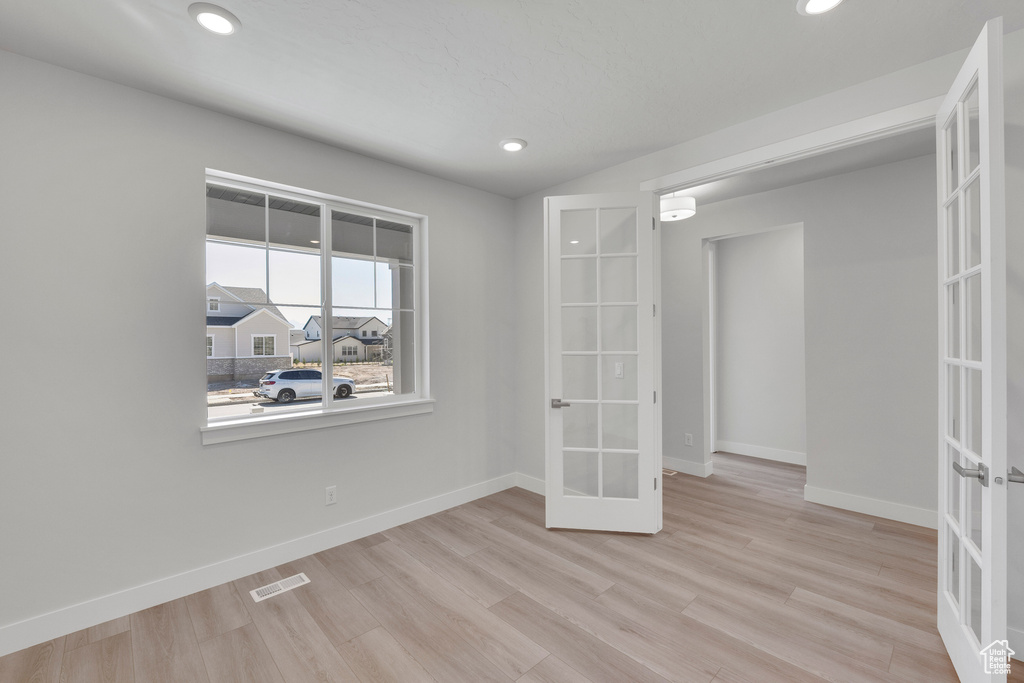 Unfurnished bedroom featuring french doors, baseboards, wood finished floors, and recessed lighting