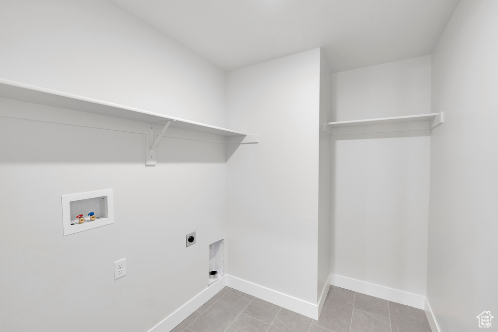 Washroom featuring electric dryer hookup, hookup for a washing machine, baseboards, and tile patterned floors
