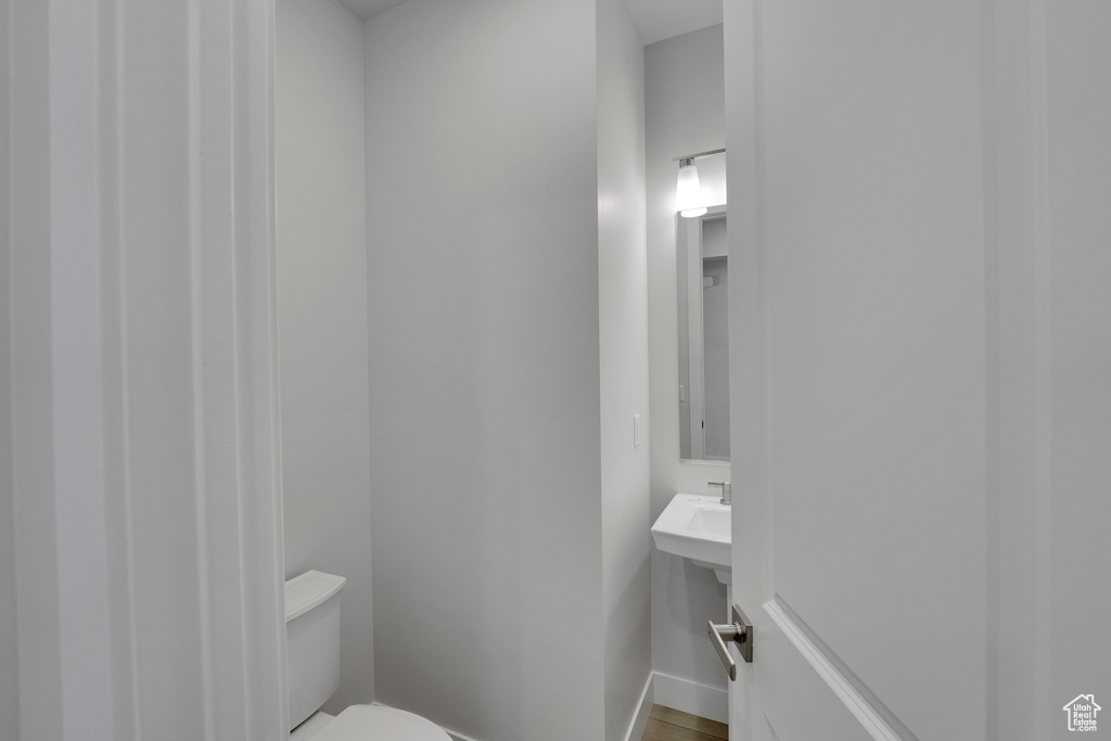 Half bath featuring toilet and baseboards