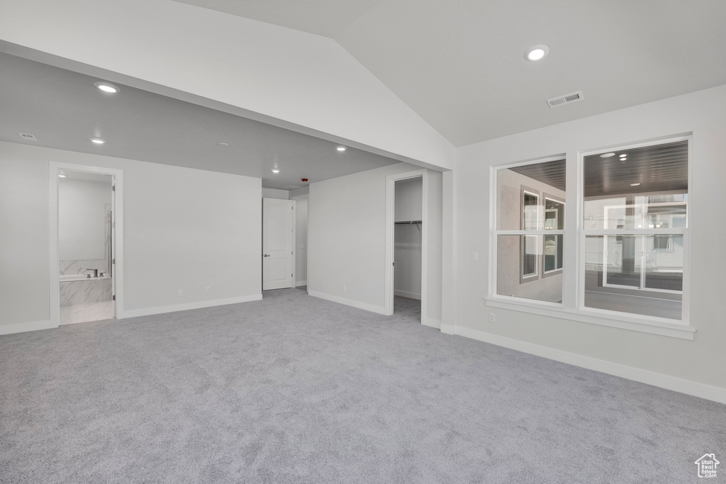 Spare room featuring recessed lighting, carpet flooring, baseboards, and lofted ceiling