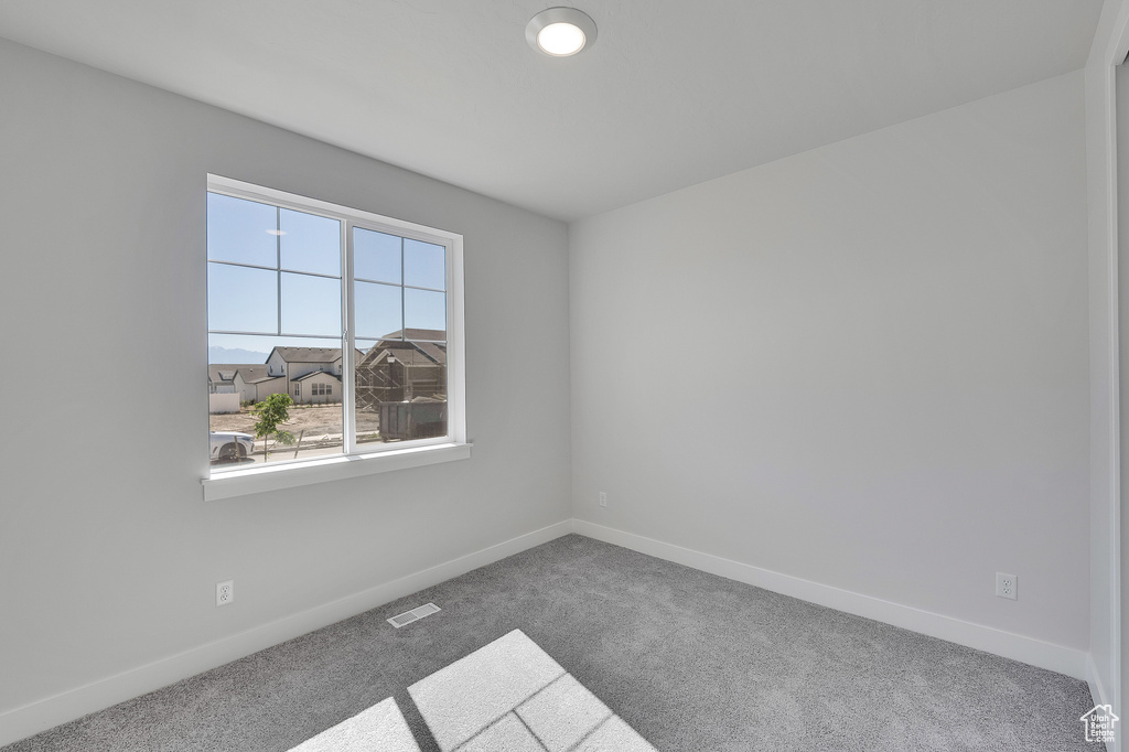 Empty room with carpet flooring and baseboards