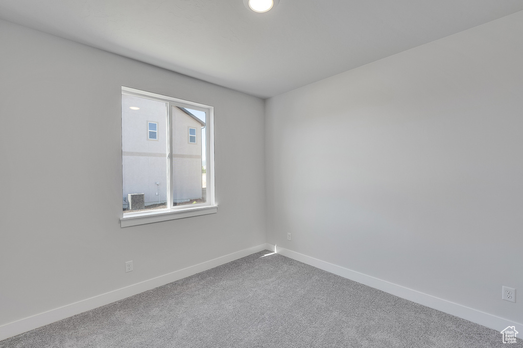 Carpeted empty room with baseboards